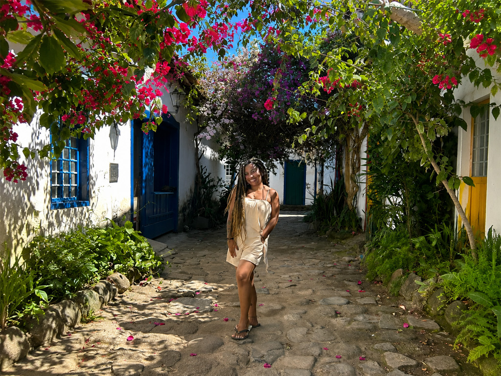 Turista em rua florida do Centro Histórico de Paraty